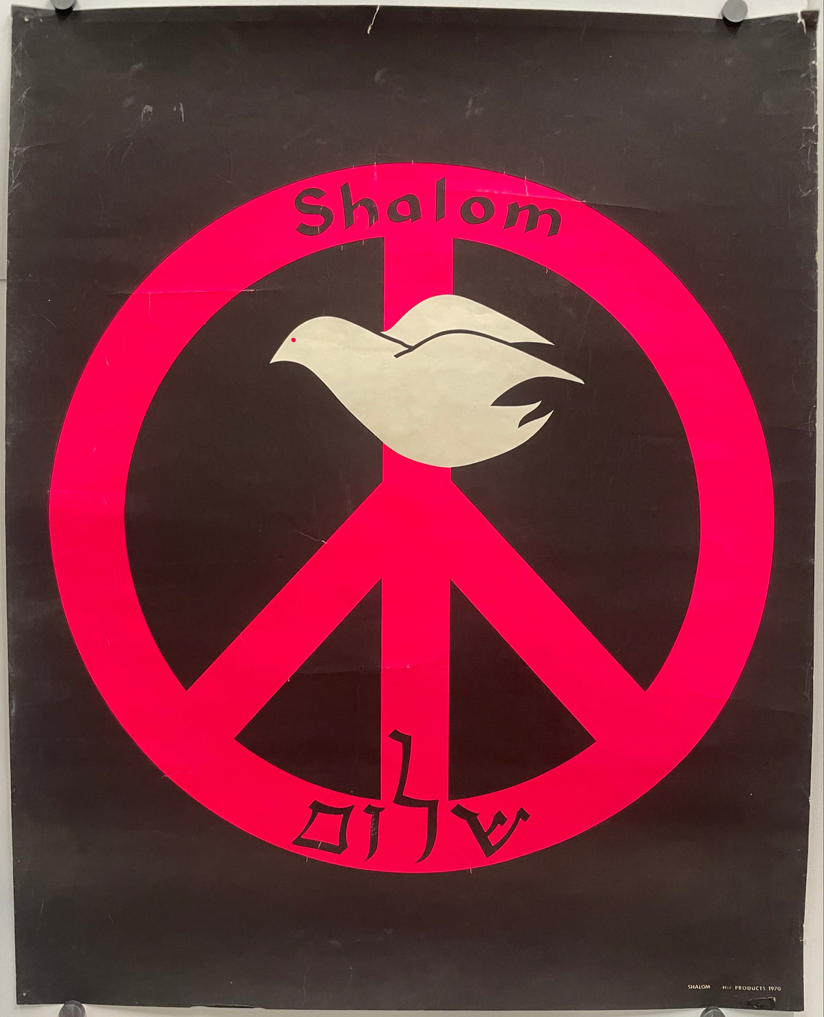 Shalom שָׁלוֹם
rare and vintage Hebrew screen-printed Peace poster - Peace, completeness, and well-being. A white dove sits at the top of the peace symbol printed in fluorescent pink pigment against a black background. Shalom is printed at the top, just above the dove, and the Hebrew spelling is at the bottom of the symbol.