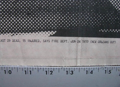 A close-up of a printed fabric or paper sample with a black-and-white halftone pattern at the top, a white printed text band across the middle, and a ruler along the bottom to show scale.