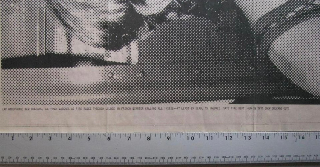 Black and white halftone printing on newsprint with a ruler along the bottom edge showing measurement scale.