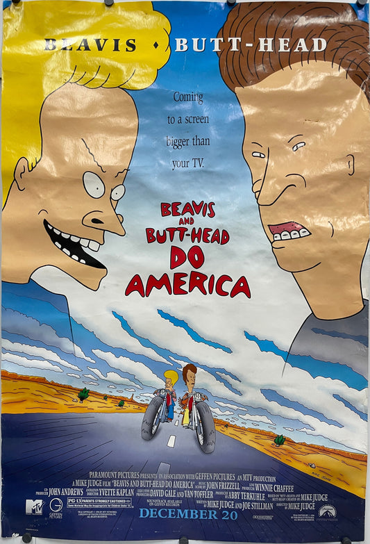 Movie poster for 'Beavis and Butt-Head Do America' with two faces and a scene of two people on bicycles. This is an original, rolled one-sheet teaser or advance film poster from 1996. The film starred Demi Moore, Bruce Willis, Robert Stack, and Cloris Leachman. This example is double-sided and would have been displayed in a lighted movie marquee.