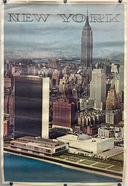 AERIAL VIEW MIDTOWN MANHATTAN SKYLINE FROM EAST RIVER LOOKING WEST UNITED NATIONS AND EMPIRE STATE BUILDINGS. New York text is printed at the top of the image of the city against a gradient blue background.