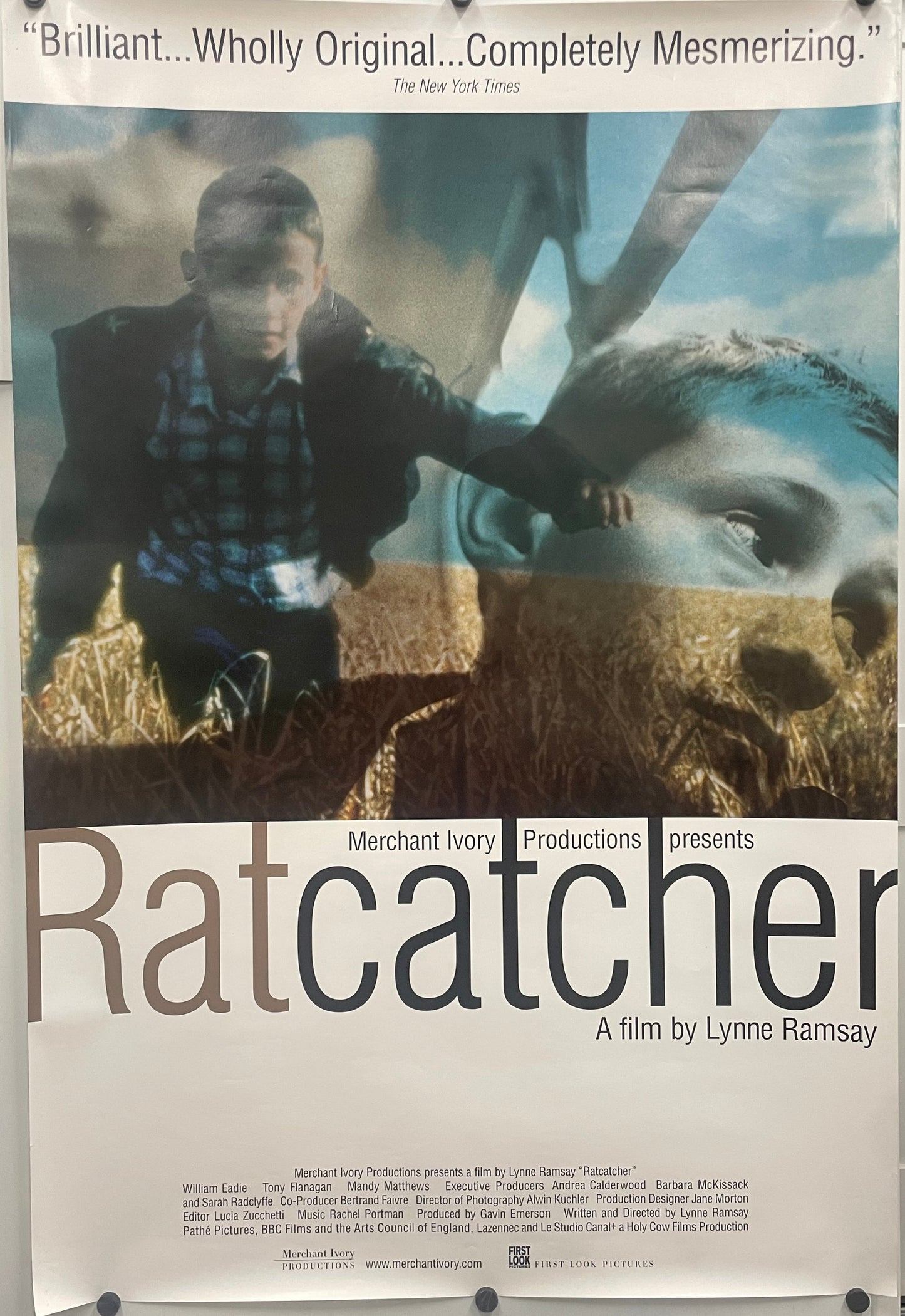 Ratcatcher, original film poster, one-sided US one-sheet rolled. Photo montage of two images spliced together - one of a boy running through a field and the other image is a close-up portrait.