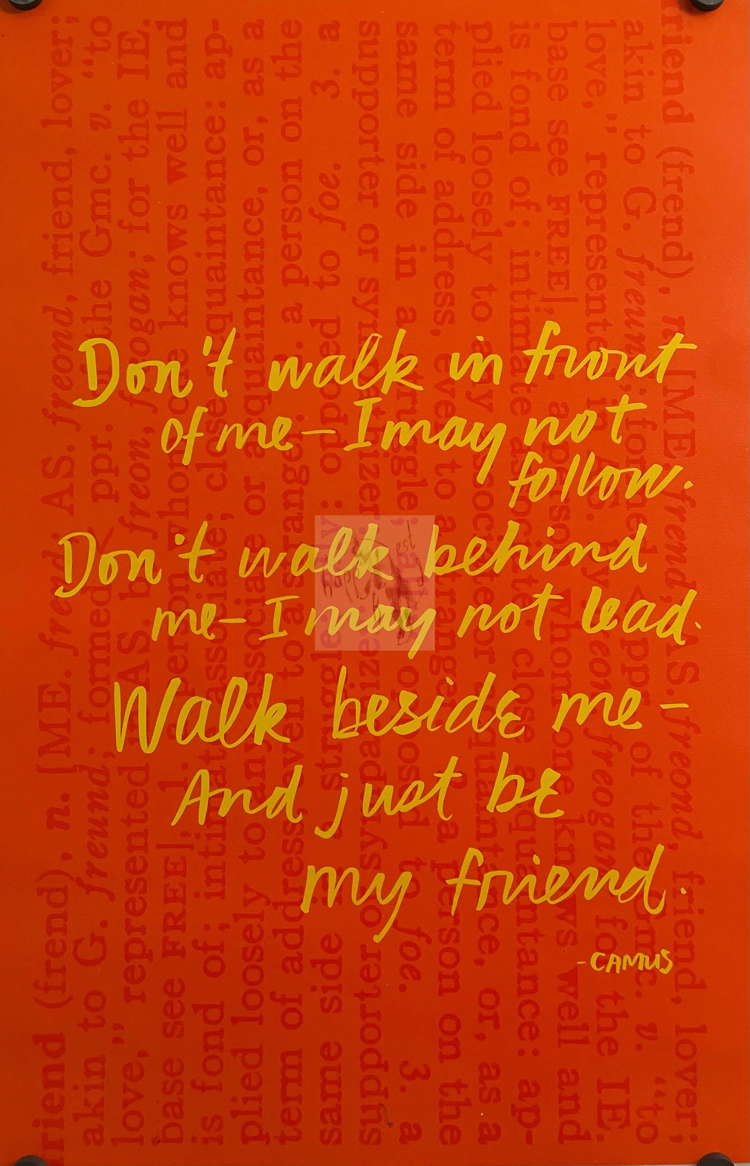 A motivational poster featuring text in yellow on an orange background, with a quote about walking in front of someone and being their friend.