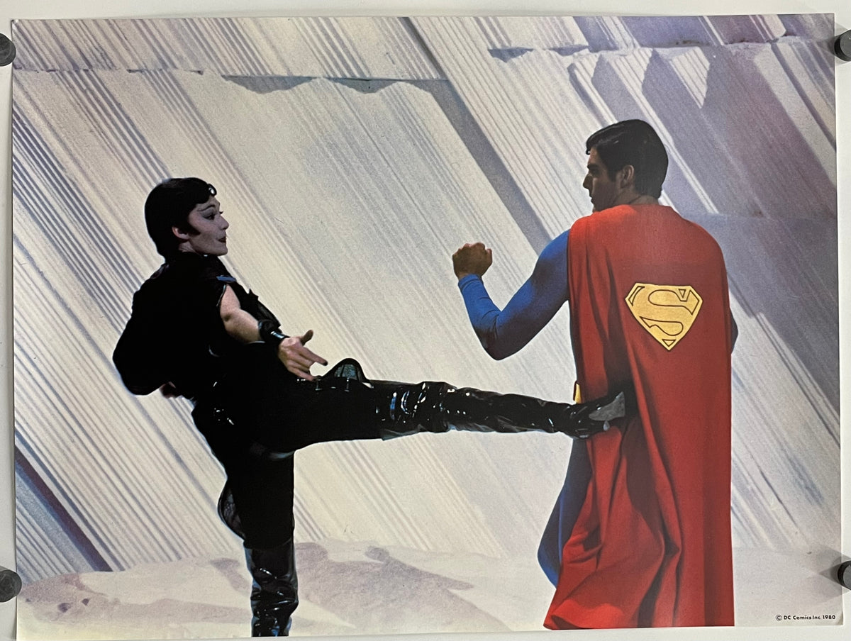 Superman in a red cape with a yellow 'S' emblem is kicking a person in a black outfit against a striped background.