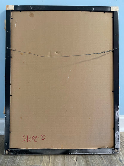 Back of a framed painting with visible wear and signature, against a blue wall.