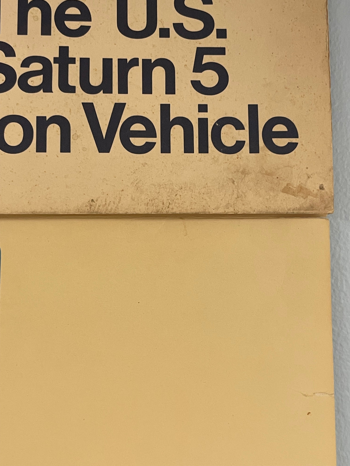 Close-up of a cardboard box with text about a U.S. Saturn 5 moon vehicle.
