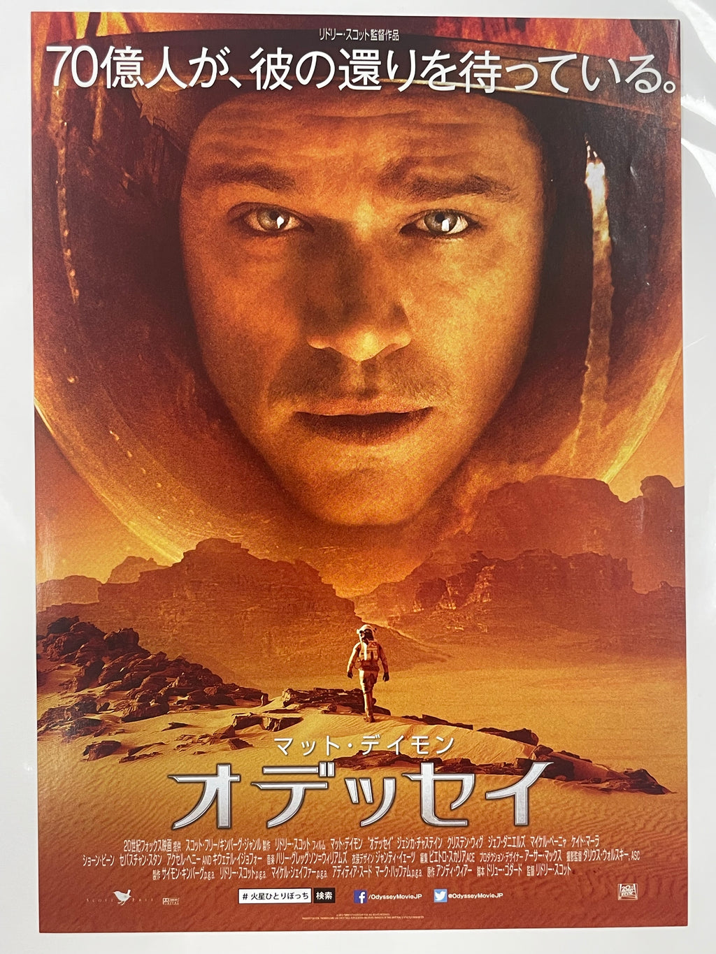 Movie poster with a person's face and desert landscape, featuring Japanese text.