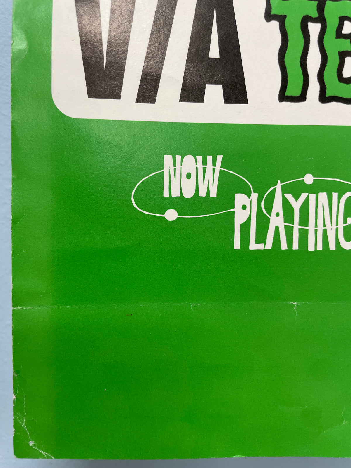 Close-up of a green vinyl record sleeve with text