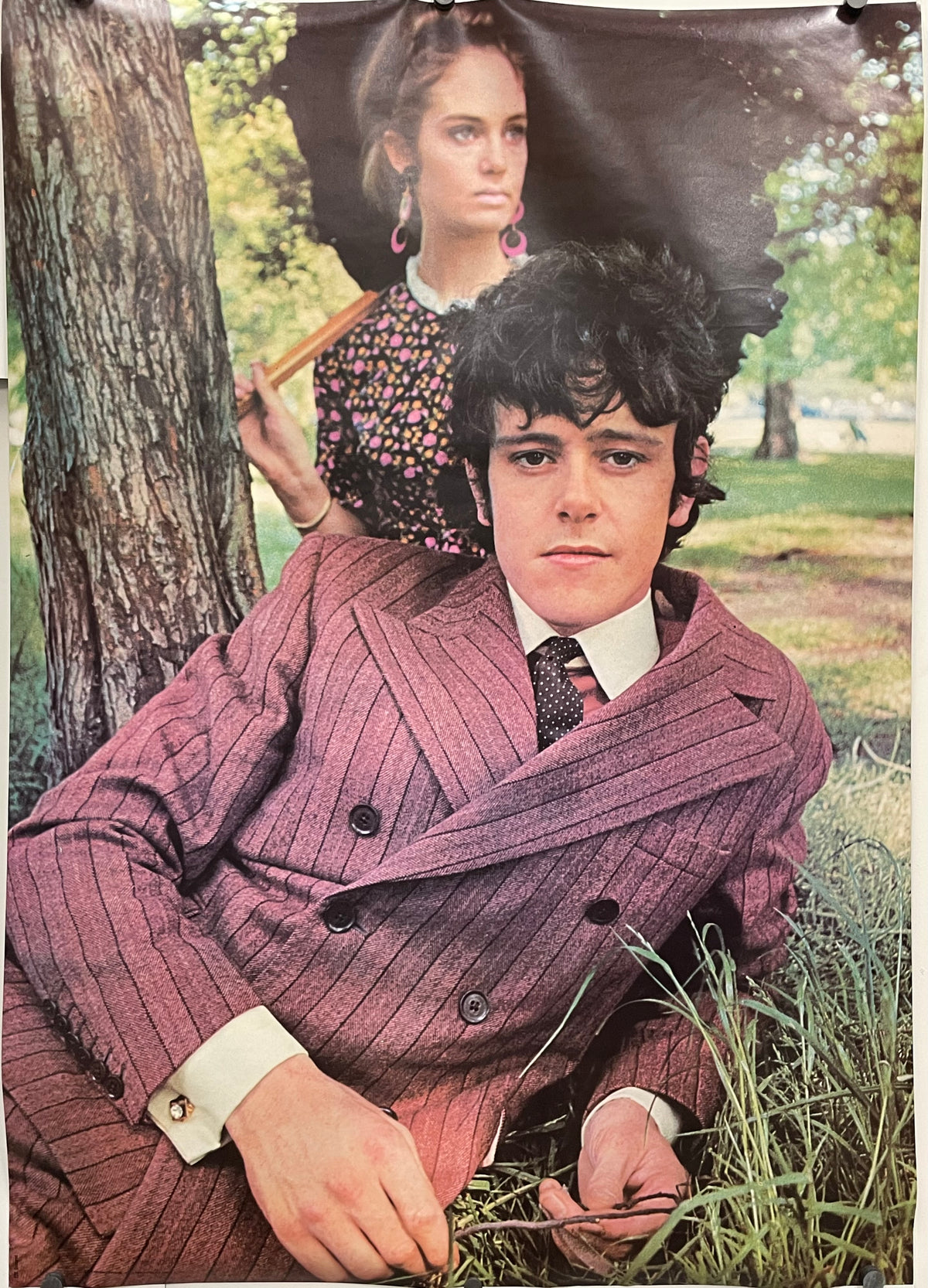 Donovan and woman  in vintage clothing sitting outdoors with a tree and grass in the background.