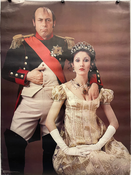 Man in historical military uniform and woman in formal gown with tiara against a brown background