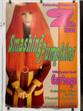 Promotional poster for a concert featuring Garbage and Smashing Pumpkins, with a stylized image of a person with red hair and a bow.