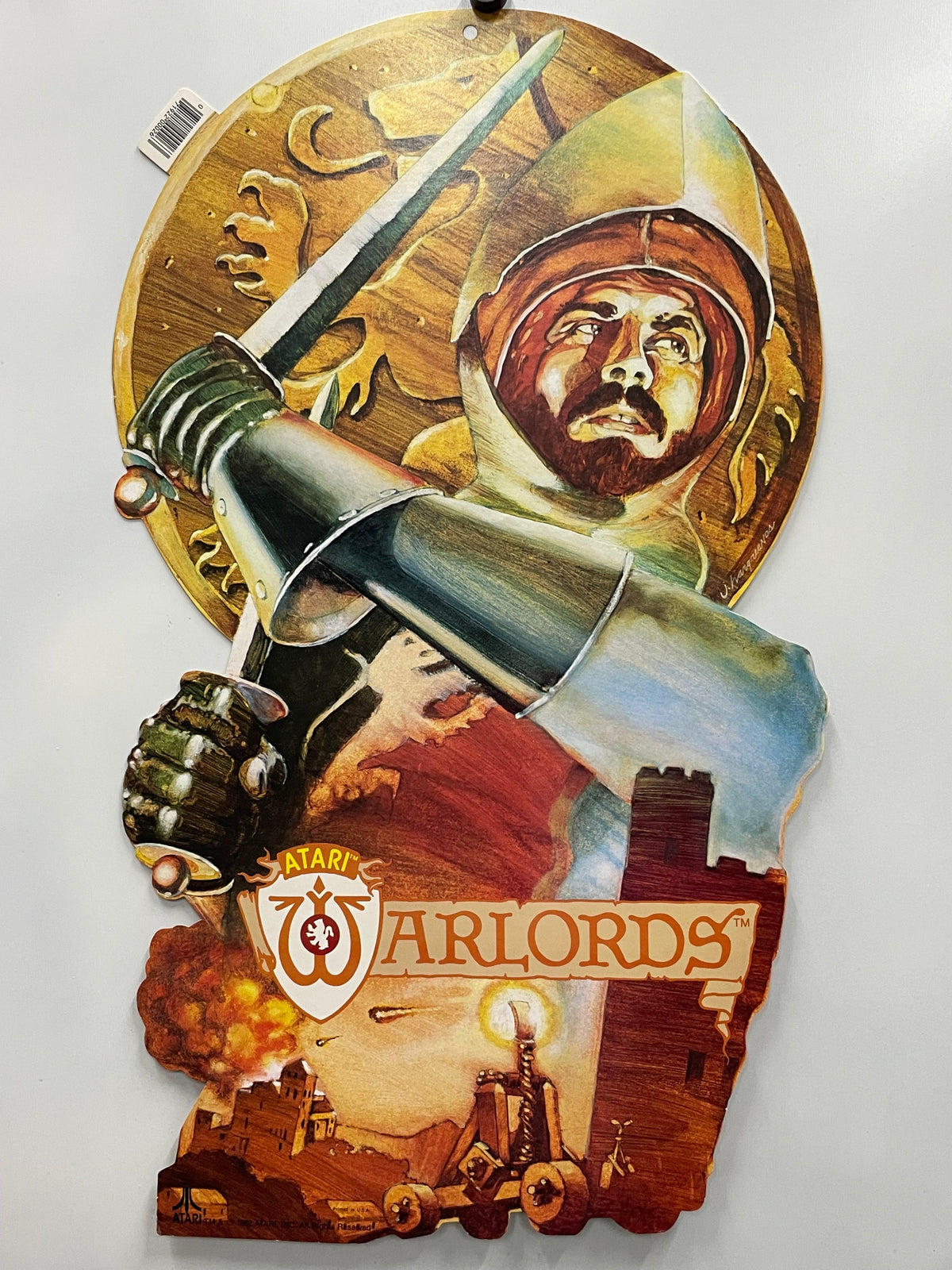 Decorative wall piece with a sword, helmet, and 'Atari Warlords' logo on a white background