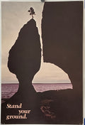 Vintage poster featuring a natural stone formation with a tree on top, overlooking a body of water, with the text 'Stand Your Ground' at the bottom.
