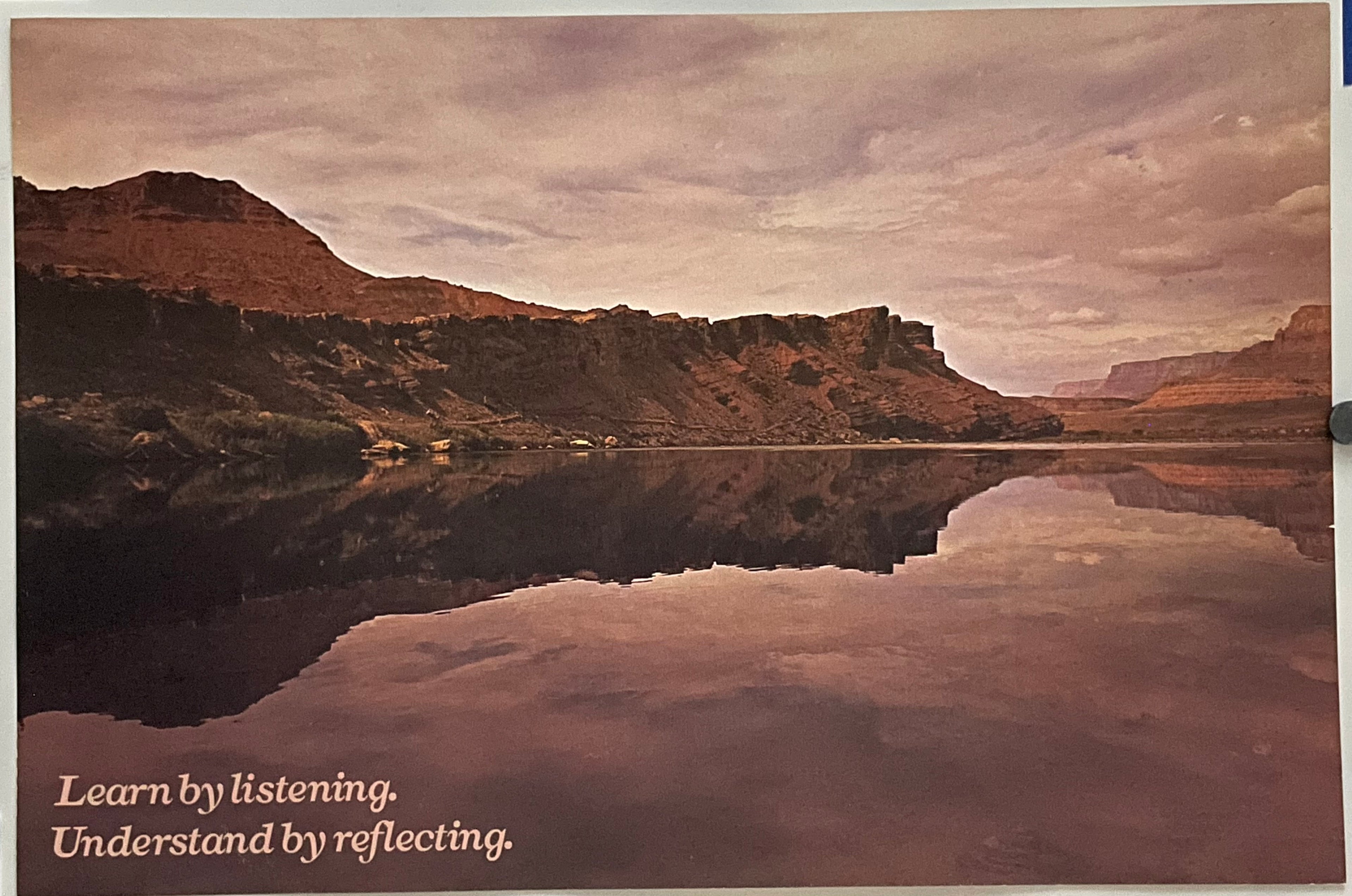 Vintage ARGUS poster featuring a landscape with mountains and a body of water, with the text 'LEARN BY LISTENING. UNDERSTAND BY REFLECTING.