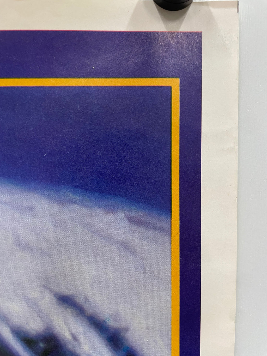 Close-up of a framed artwork with a blue background and gold border.