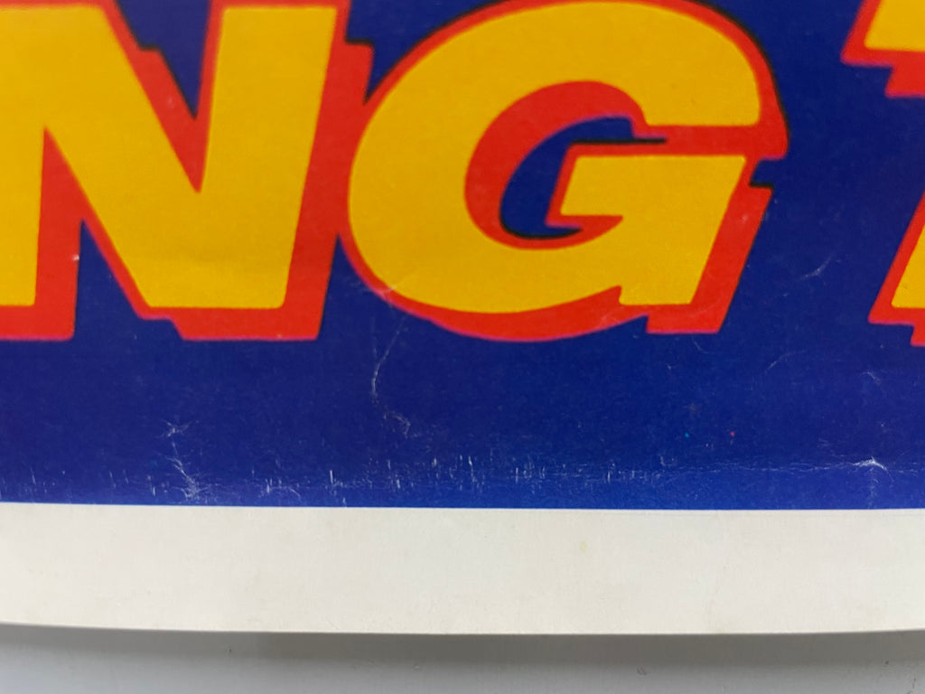 Close-up of a sign with large yellow letters on a blue background