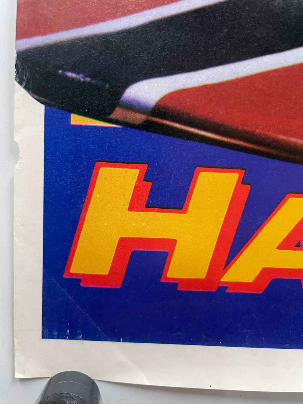 Close-up of a vintage poster with a portion of the graphic and  text on a blue background.