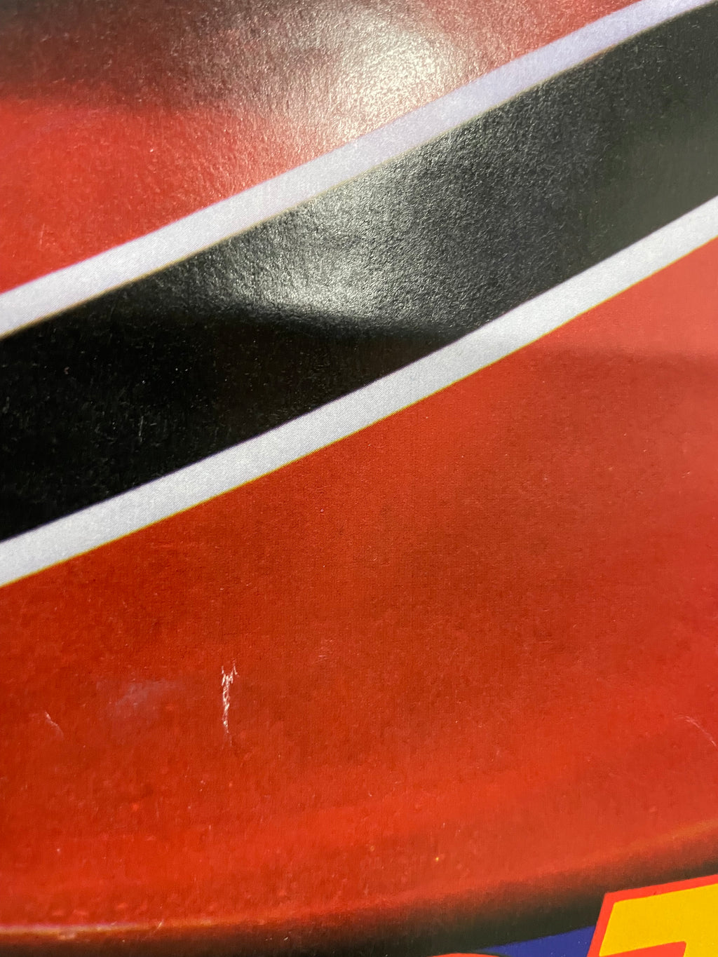 Close-up of a red surface with a black and white stripe