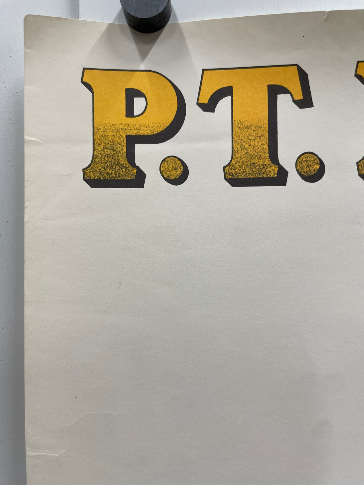 Close-up of a piece of paper with large, yellow letters on a white background