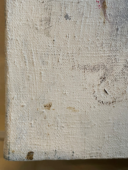 A close-up of a textured canvas or painted wood surface in an off-white, distressed finish with visible brushstrokes, scuffs, and small brown specks.